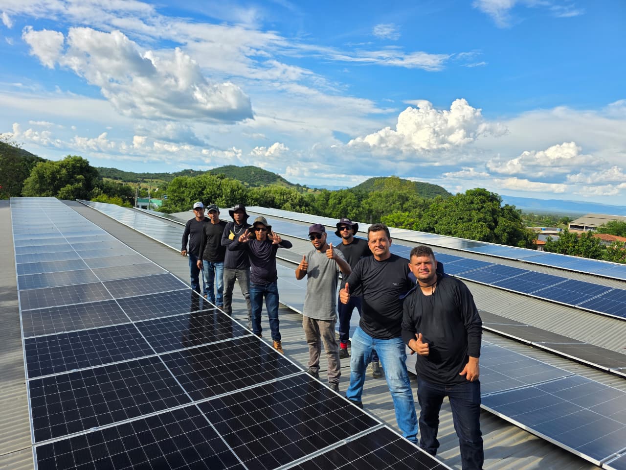 Equipe da Condesul reunida em cima de um telhado com painéis solares recém-instalados